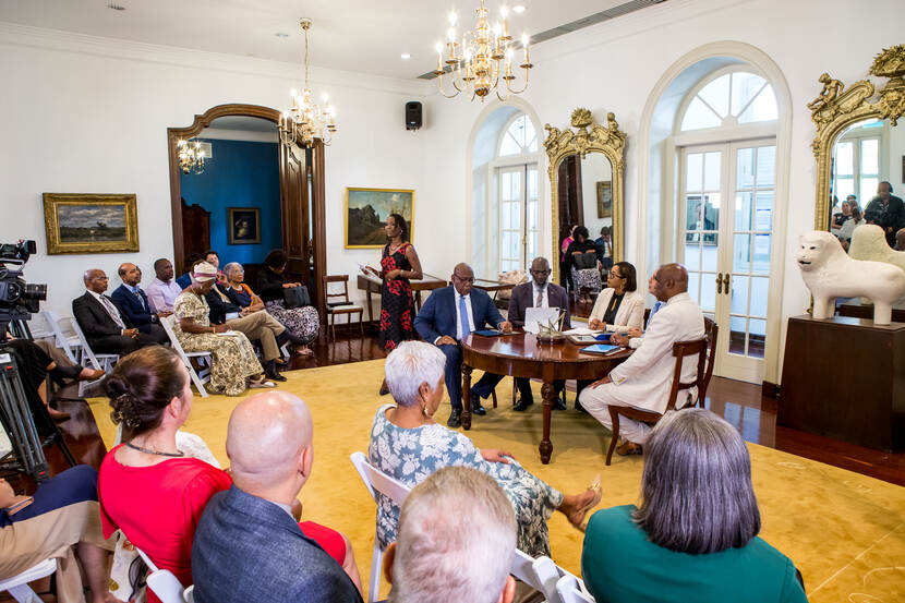 Zicht op de volle zaal tijdens het rondetafelgesprek met vooraan alle deelnemers en de moderator.